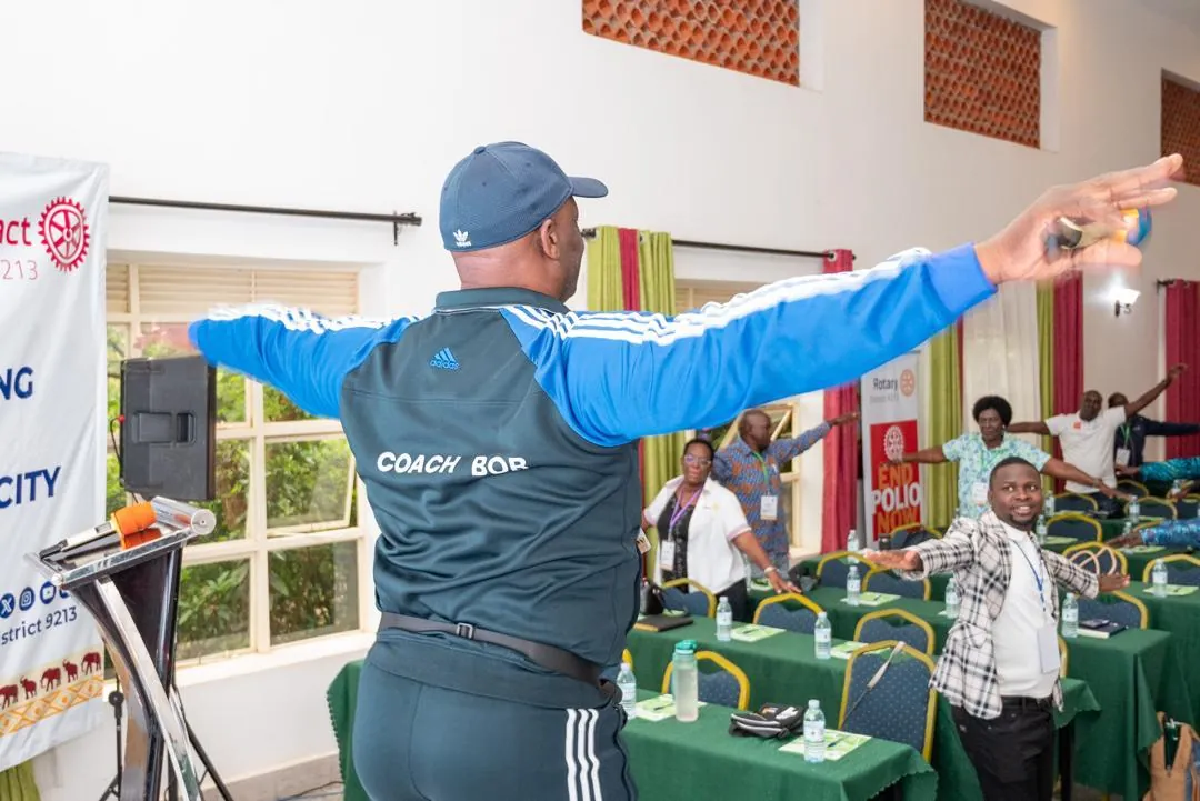 Coach Bob Ssebugwawo leading a corporate stretching session for office staff